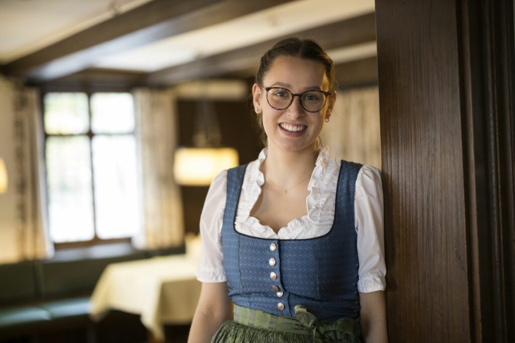 Nachhaltigkeit Lächelnde Service-Mitarbeiterin im Dirndl