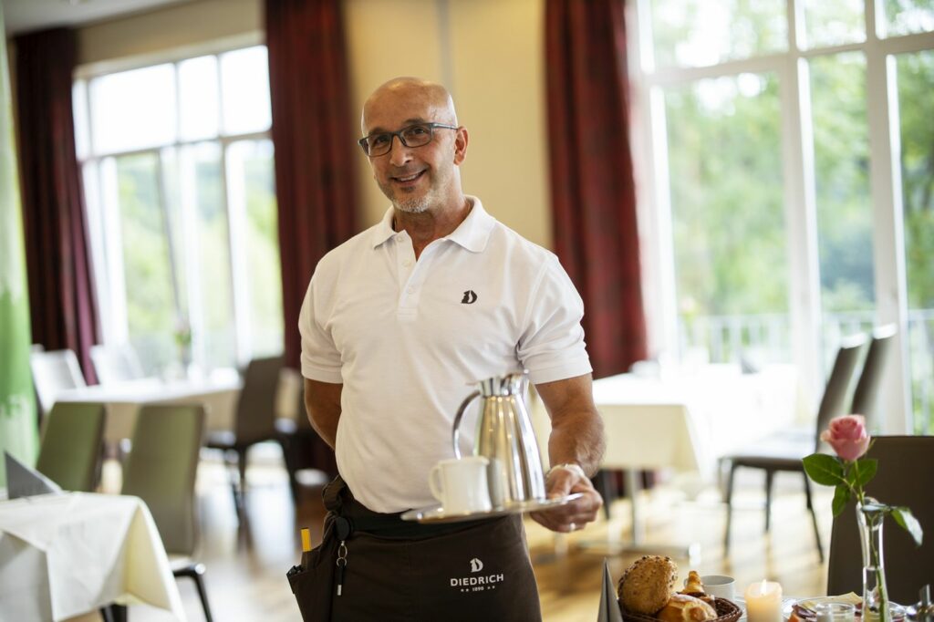 Nachhaltigkeit Mitarbeiter im Frühstücksservice serviert Kaffee